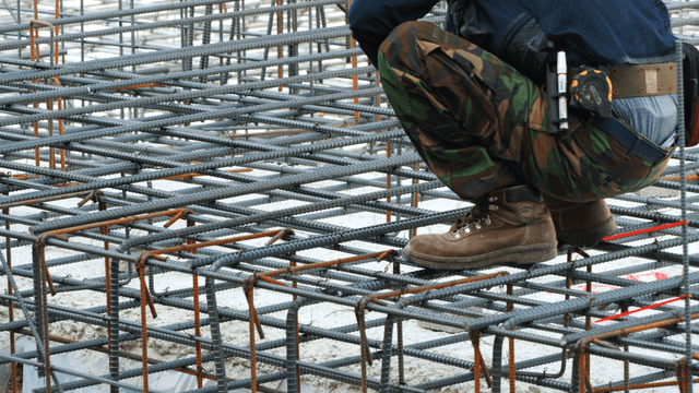 Worker assembling steel bars at a construction site