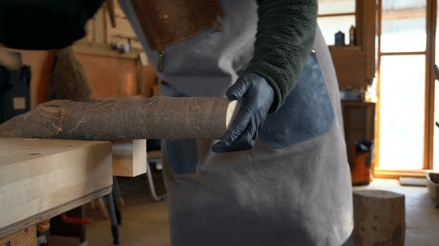 Carpenter marking and sawing wood in workshop