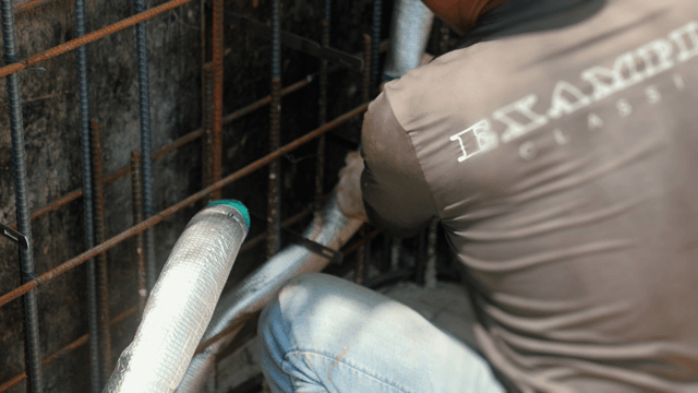 Worker installing insulation on pipes