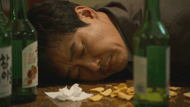 Man asleep on table with snacks and bottles