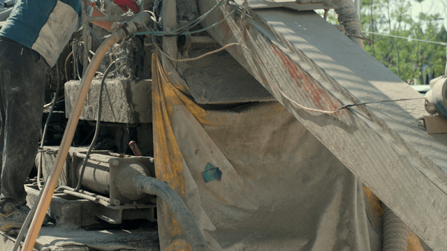 Worker touching a dusty industrial machine