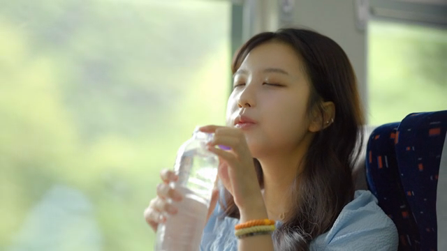 기차에서 물을 마시는 여성