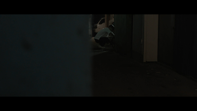 Busy student crouching in dark alley
