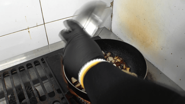 Noodles added to black bean sauce stir-fried in a pan