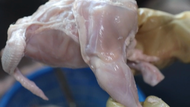 Raw chicken being prepared in a kitchen
