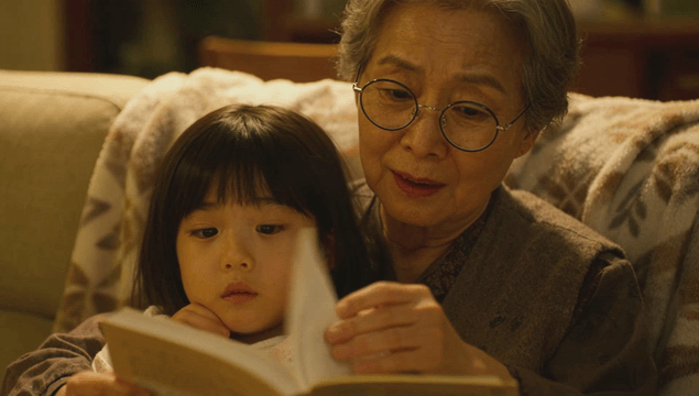 Grandmother reading a book with her granddaughter