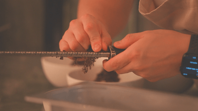 Chef grating truffles onto a plate in the kitchen