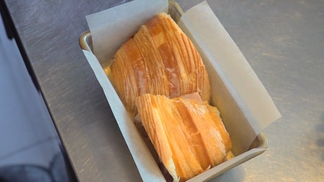 Pouring beaten egg over layered pastry