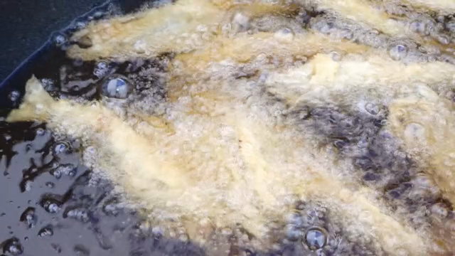 Fish frying in hot oil in a pan
