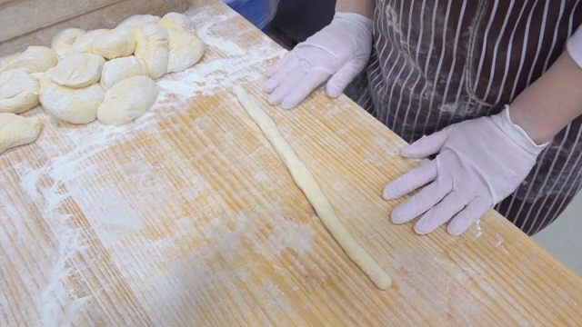 Hands kneading dough on a floured surface