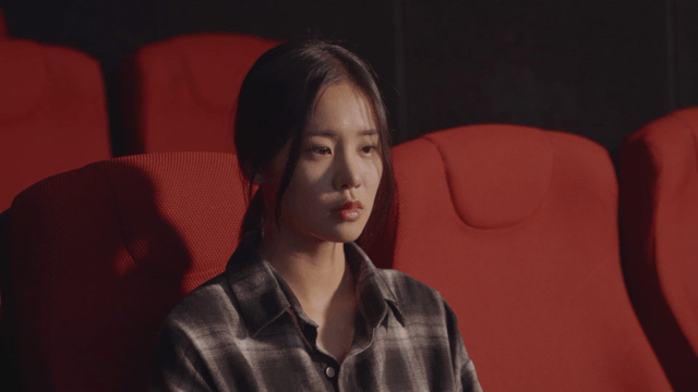 Woman sitting in a theater seat, absorbed in the experience