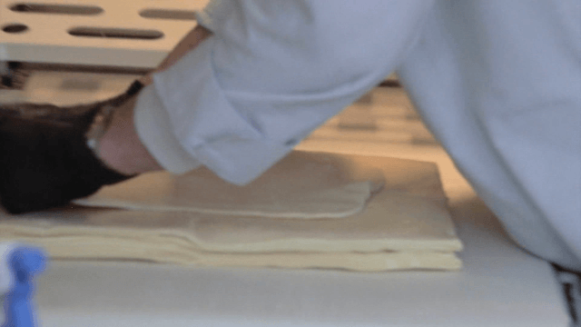 작업대에서 반죽을 겹겹이 쌓아내는 제빵사