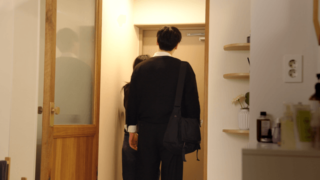 Woman adjusting man's collar in cozy apartment
