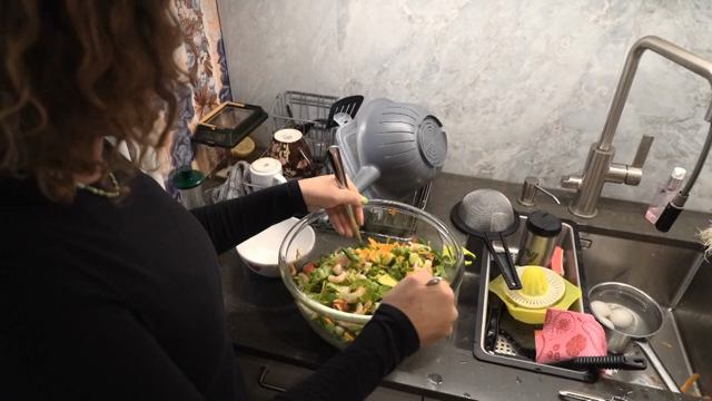 A person preparing a fresh salad in the kitchen