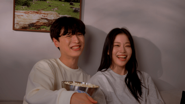 Couple laughing while watching comic movie on sofa