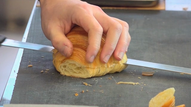 Slicing a croissant on a kitchen counter