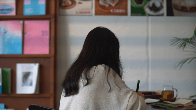 Woman writing in a cozy cafe