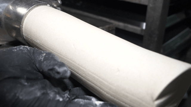 Cylindrical buckwheat dough coming out of a mixer