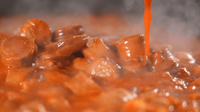 Spicy budaejjigae  filled with sausages as rich broth is poured