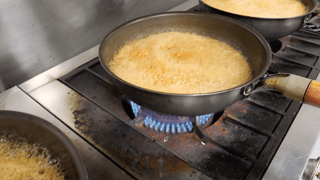 Pans with boiling liquid on a stove