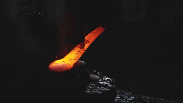 Hot metal being forged in workshop