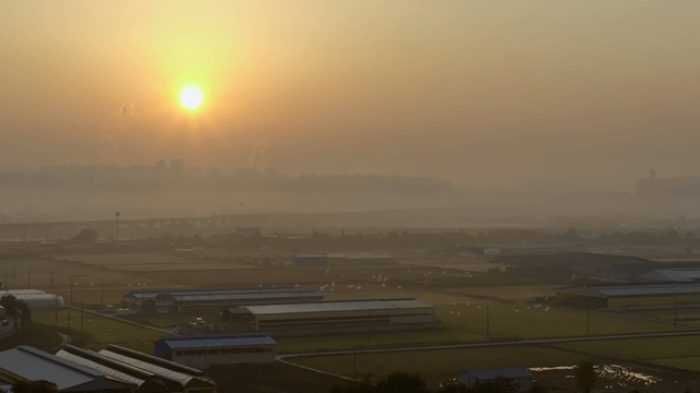 Sunrise over a misty rural landscape