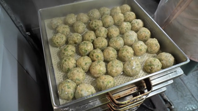 Rolling dumplings being steamed in a steamer