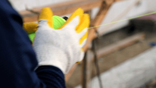 Worker measuring with a string line
