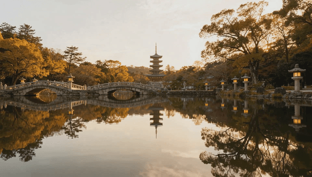 Traditional tower and bridge over pond at sunset