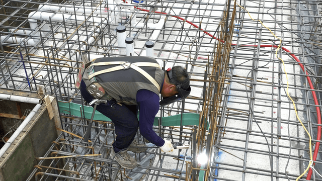 Construction worker welding steel bars
