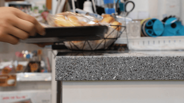 Bakery counter with pastries and hands