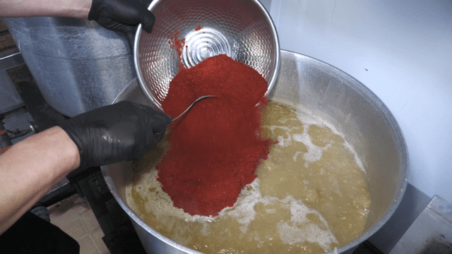 Red pepper powder added into boiling broth