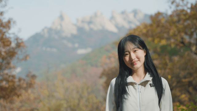 Smiling woman with view of autumn mountain summit