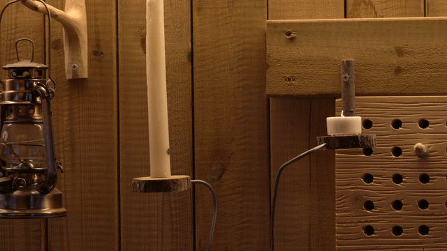 Wooden wall of a workshop with candles and lanterns