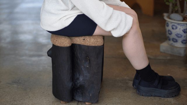 Person sitting on a wooden chair indoors