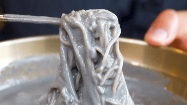Chopsticks lifting mixed black bean buckwheat noodles