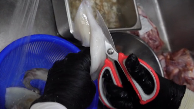Cleaning and preparing squid in a kitchen