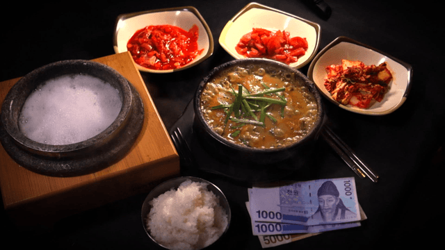 Hot stone pot rice and loach soup served with Korean banknotes