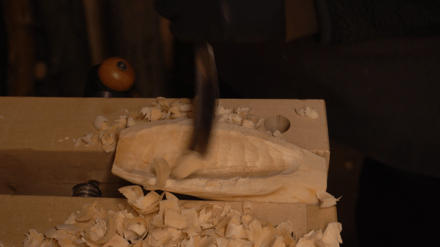 Wood piece being carved with a chisel