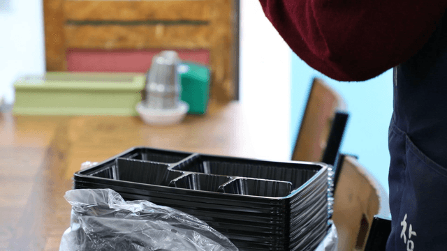 Hands arranging plastic trays indoors