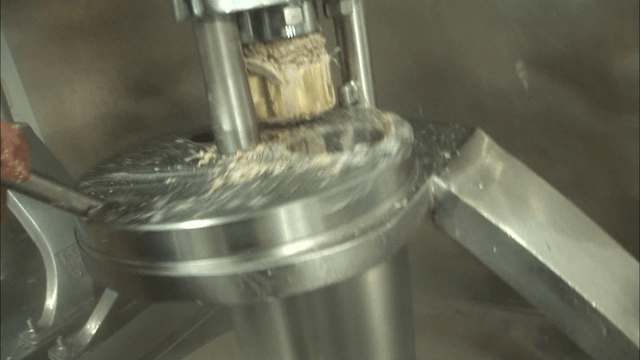 Hands preparing dough in a machine