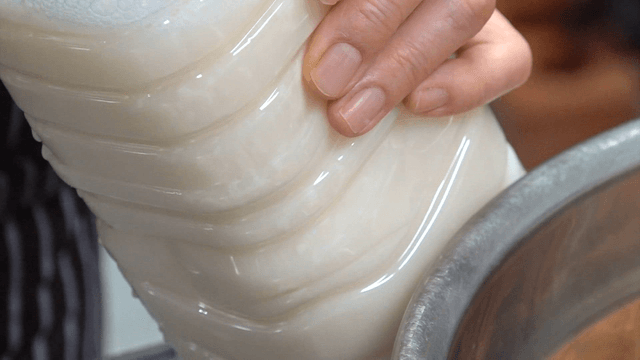 White soy milk poured into a plastic bottle