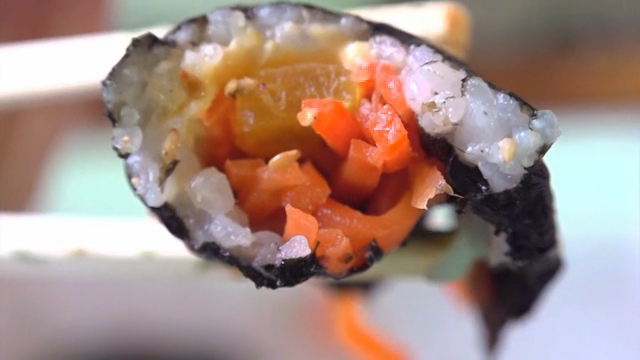 젓가락으로 집은 김밥의 클로즈업