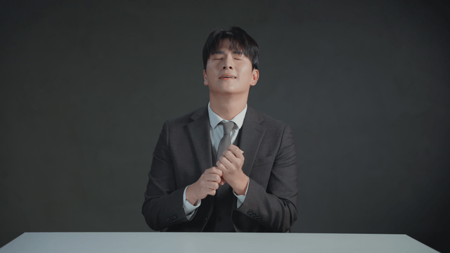 Man in a suit counting money at a desk with a satisfied expression