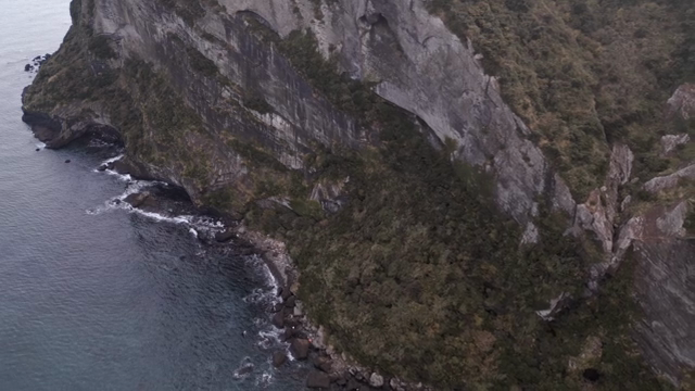 A rugged cliffside meeting the ocean waves