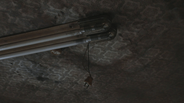 Old fluorescent light on a patterned ceiling