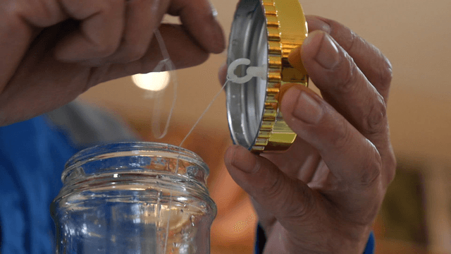 Hand Tying String on Lid of Infusion Jar