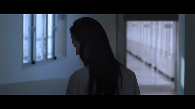 Woman walking down a dimly lit hallway