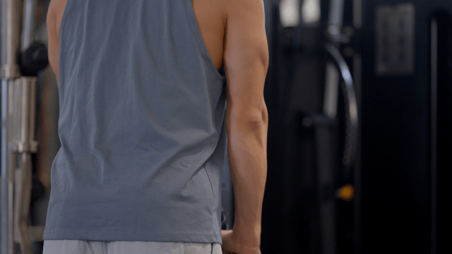 Man doing arm pulldown workout with rope at gym