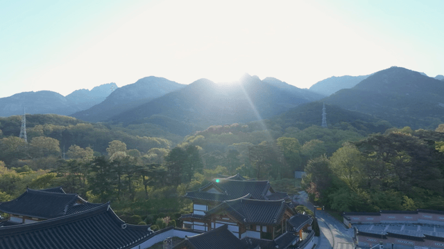 High mountain with sunrise behind traditional hanok village